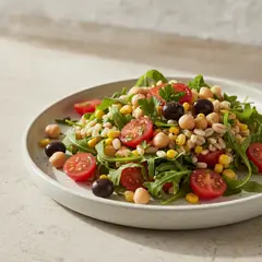 Insalata d'orzo con pomodorini, mais e olive