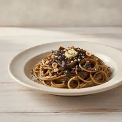 Spaghetti con crema di aglio nero, liquirizia e nocciole
